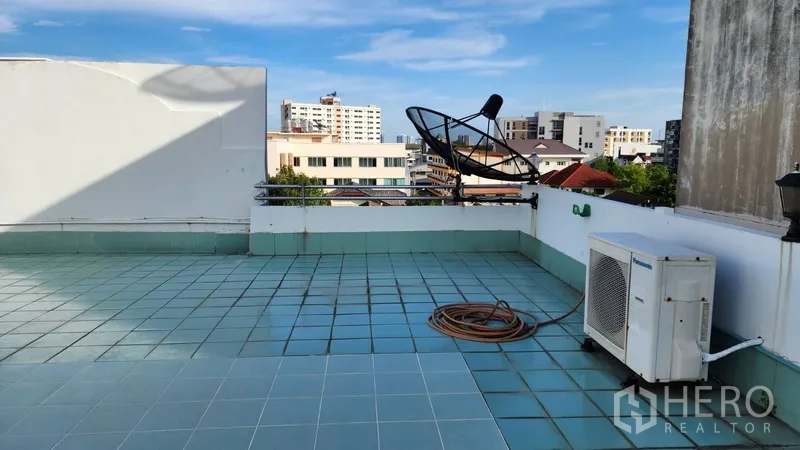 Office Space for rent or sale in Khlong Toei, Bangkok - Rooftop terrace with tiled floor, city views, satellite dish, and AC unit.