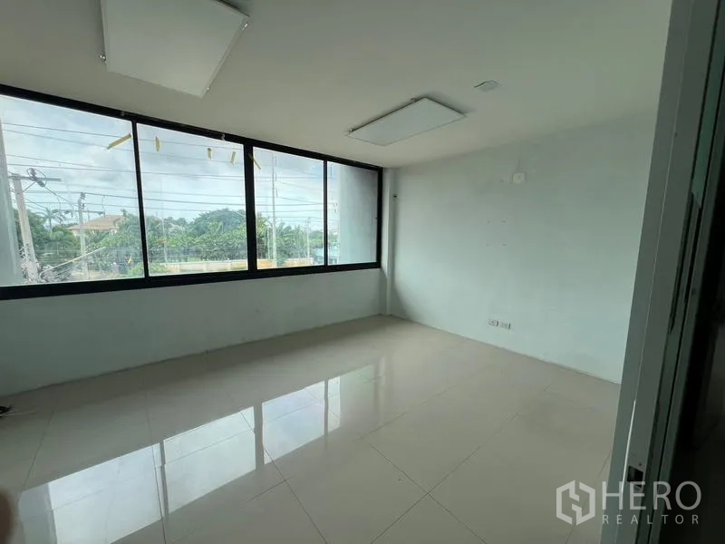 Warehouse for rent in Bang Phli, Samut Prakan - Corner office with large street-facing windows and glossy tiled flooring.