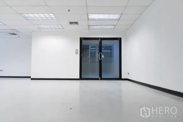 Office Space for rent in Ratchathewi, Bangkok - Double glass doors leading into a modern white office with a drop ceiling and bright lighting.