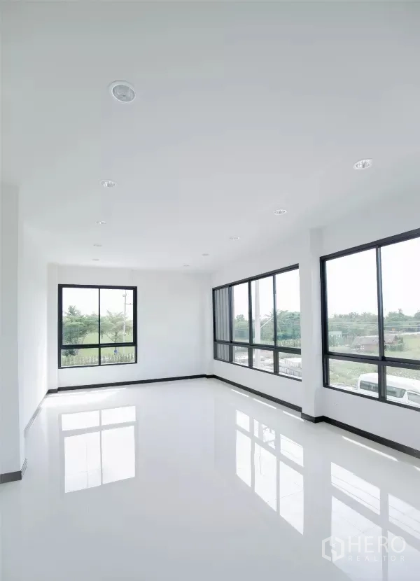 Factory for rent or sale in Nakhon Pathom - Bright second-floor office with large windows and glossy white flooring overlooking greenery.