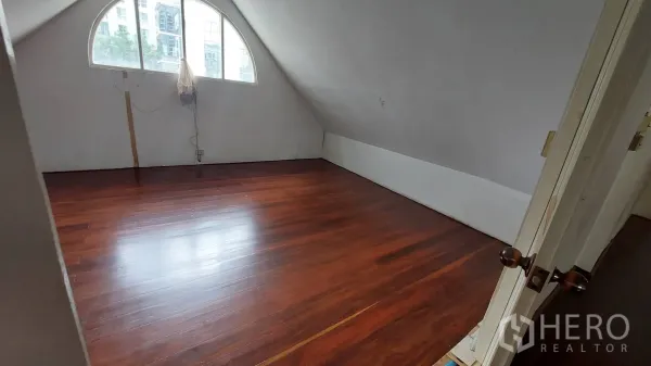 Office Space for rent in Watthana, Bangkok - Room with a sloped ceiling and arched window, polished wooden floor and city outlook, ideal for a private office or meeting room.