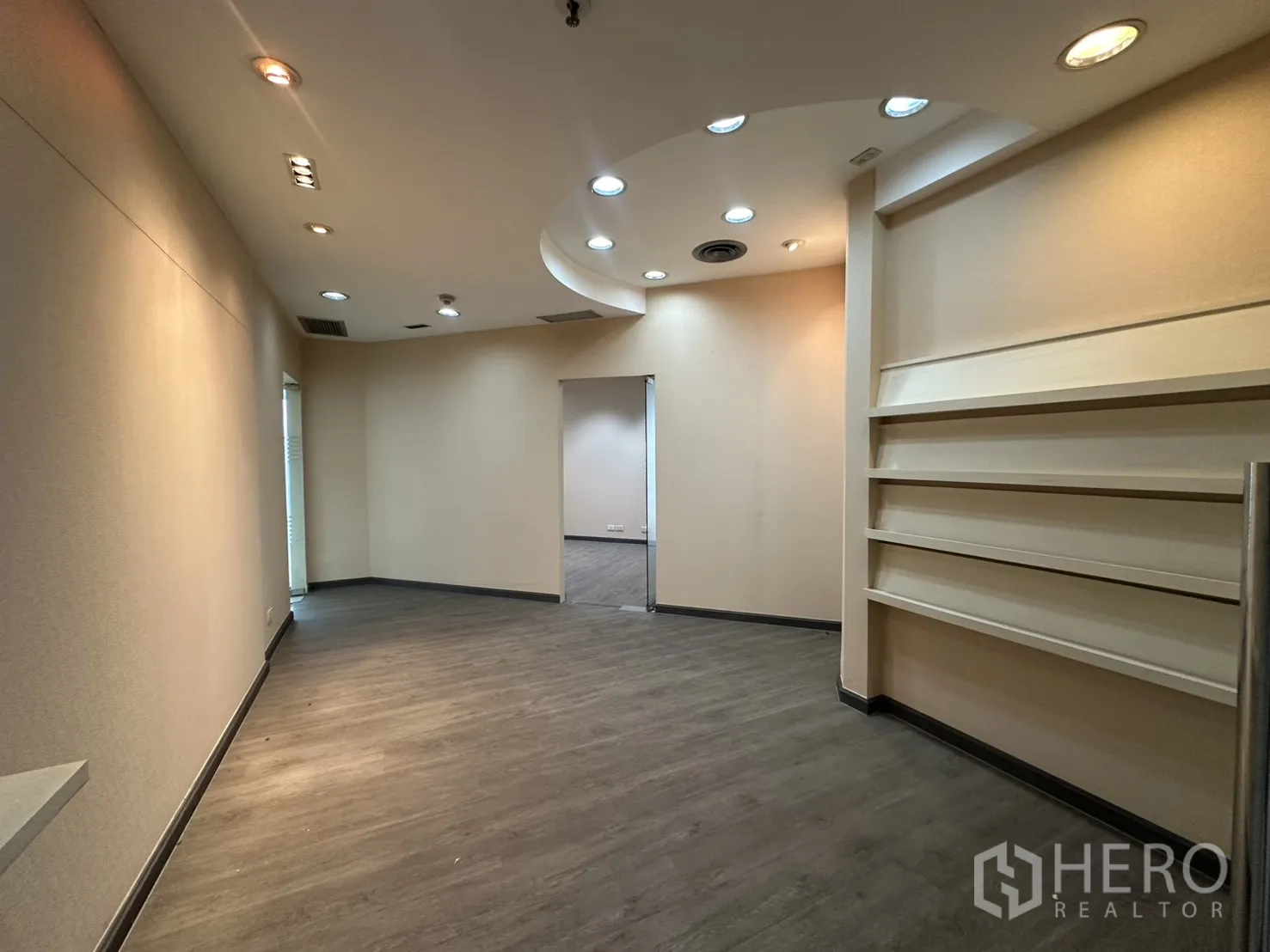 Office Space for rent in Bang Rak, Bangkok - Curved-ceiling lobby area with recessed downlights, built-in shelves and wood-look flooring.