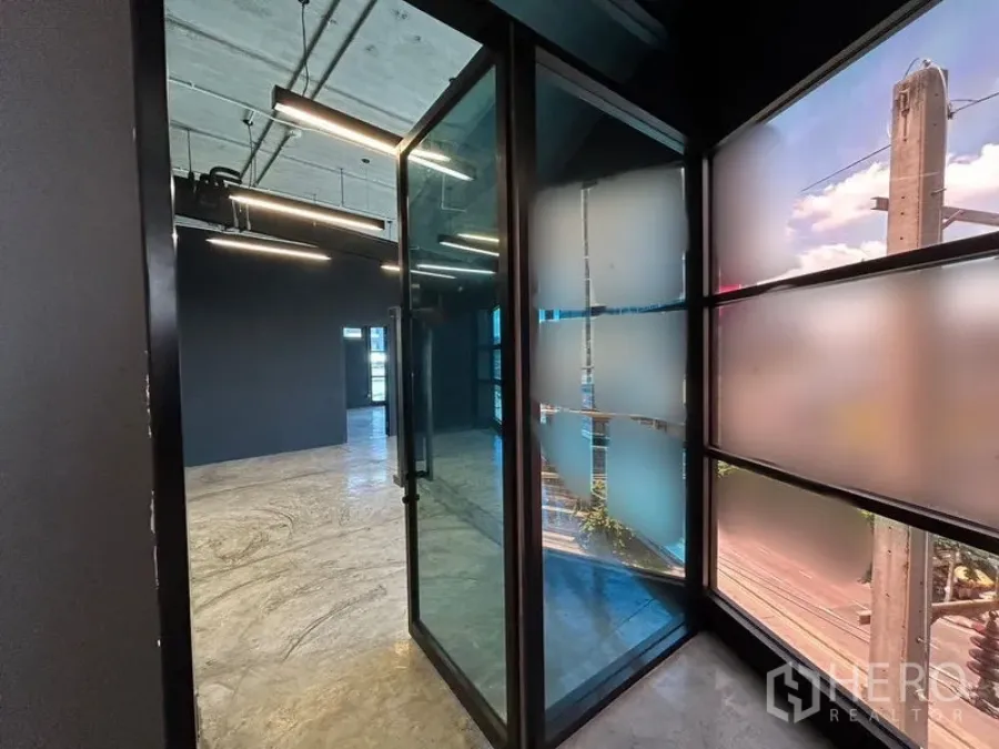 Office Space for rent in Chatuchak, Bangkok - Entry corridor with glass swing door and frosted glass panels beside windowed wall.