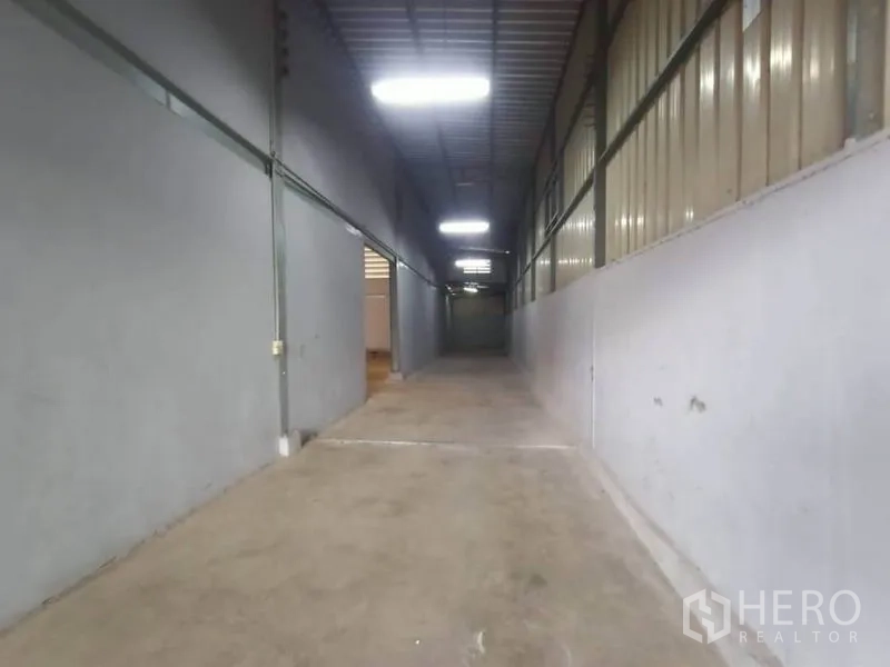 Factory for rent or sale in Mueang Samut Sakhon, Samut Sakhon - Long covered corridor suited for storage or loading access with overhead lighting.