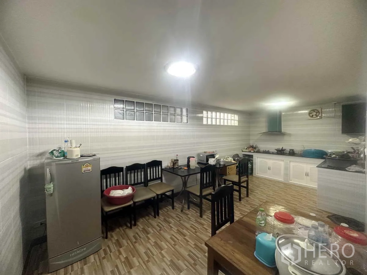 Detached House for sale in Pathum Thani - Large Thai-style kitchen with tiled walls, gas hob, extractor and dining area.