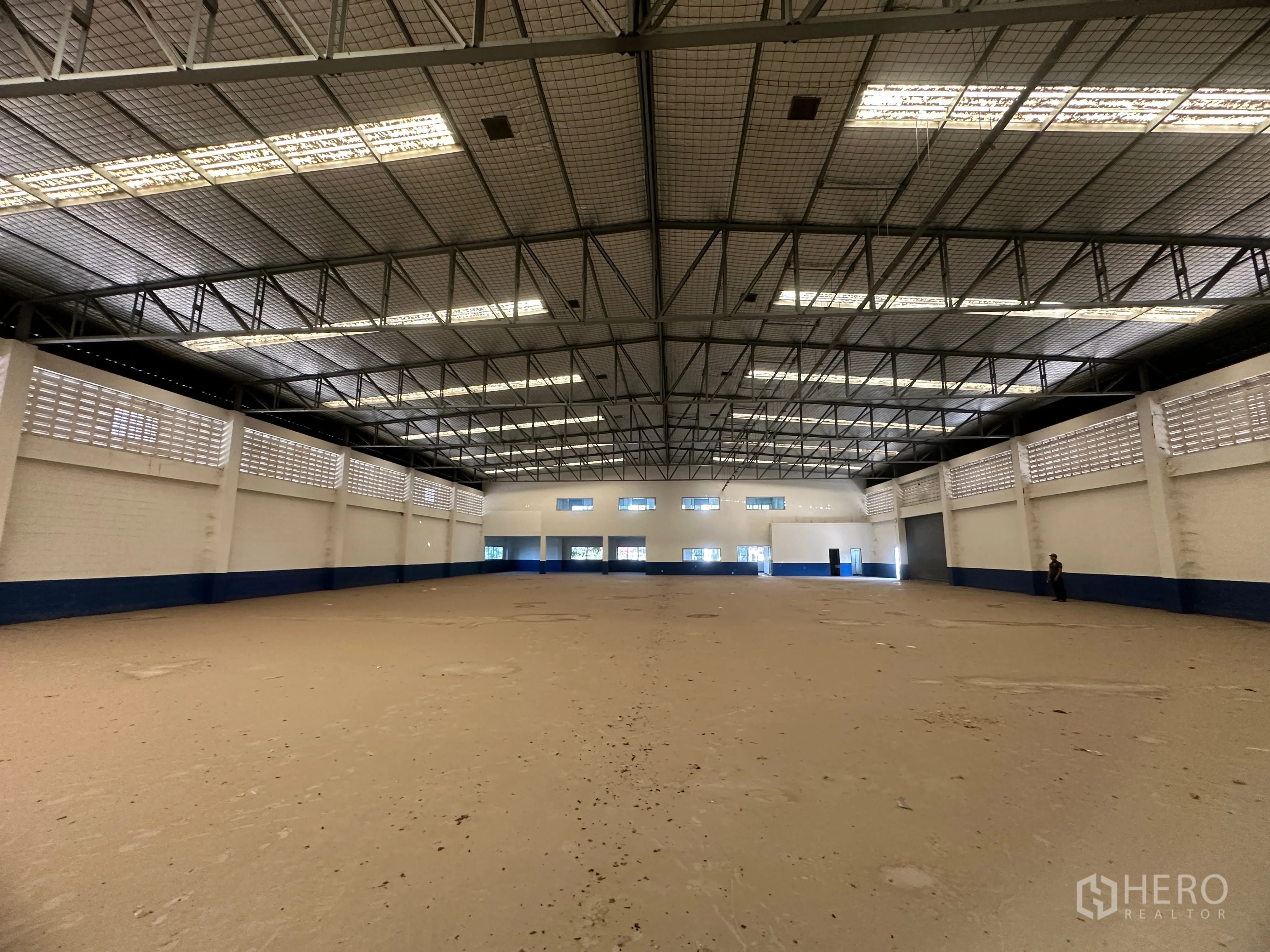 Factory for rent in Bang Pa-in, Phra Nakhon Si Ayutthaya - Expansive production hall with ventilated block walls and a high, lit roof.