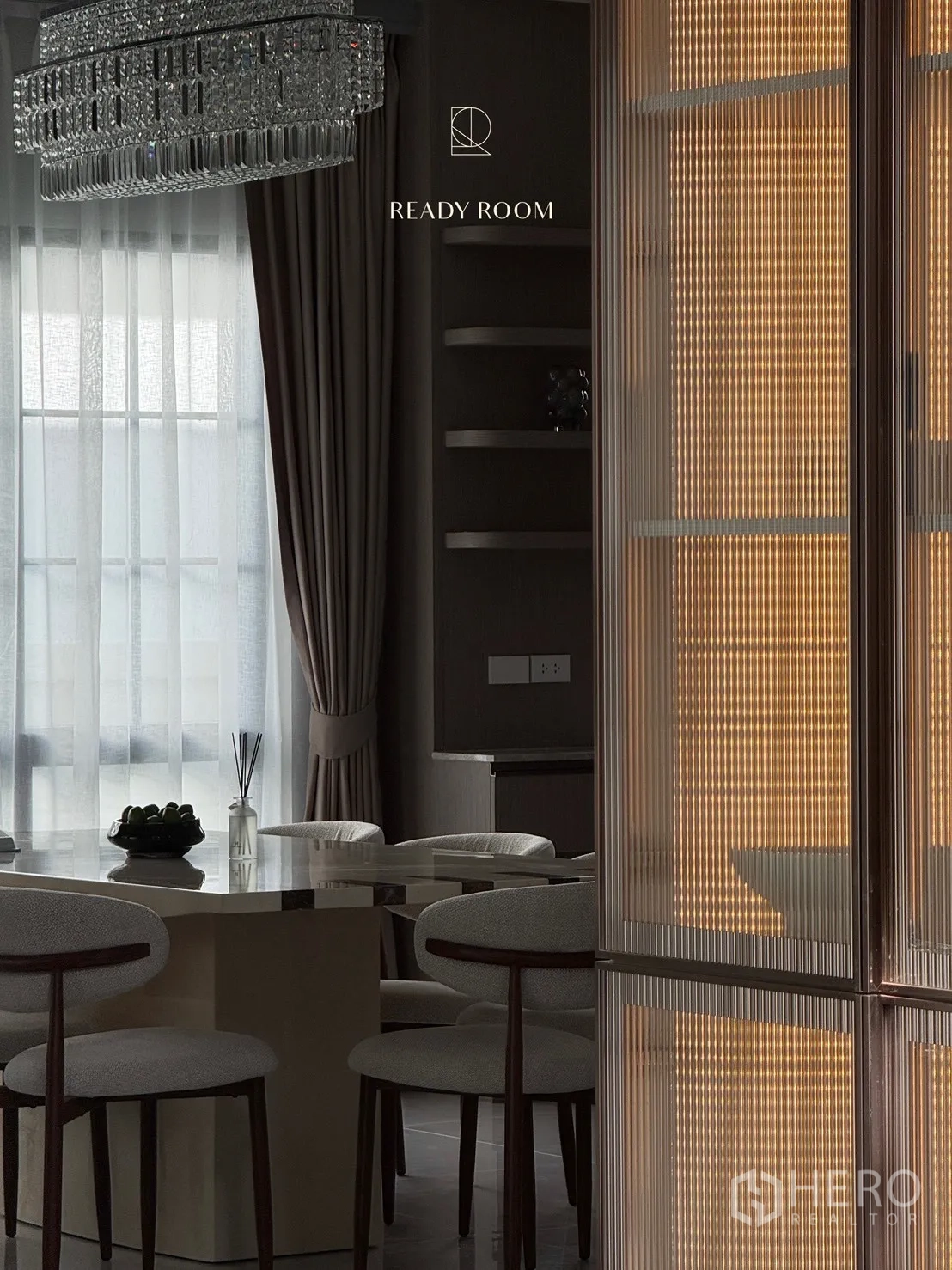Detached House for rent or sale in Bang Phli, Samut Prakan - Dining area under a crystal chandelier with an illuminated fluted-glass cabinet feature.