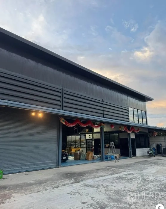 Warehouse for sale in Thanyaburi, Pathum Thani - Front facade of the warehouse with glass-front office and covered loading bays.
