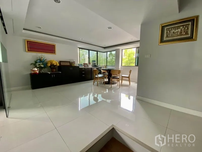 带办公室的家 出租或出售在Yan Nawa, Bangkok - 角落会议区，圆桌、大幅转角窗与深色收纳柜。