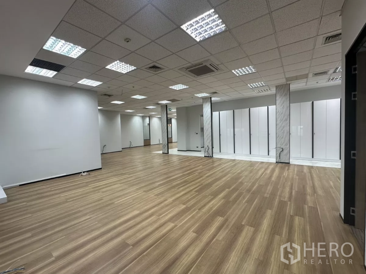Office Space for rent in Watthana, Bangkok - Open workspace with wood floors, white storage walls and grid ceiling lighting.