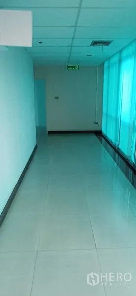 Office Space for rent in Huai Khwang, Bangkok - Wide hallway with teal-tinted windows and polished tile floors.