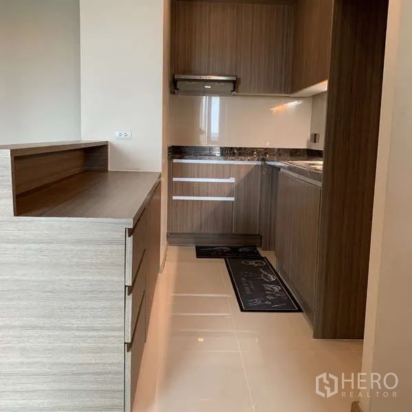 Condominium for rent - Galley kitchen with wood cabinets, range hood, and glossy tiled floor.