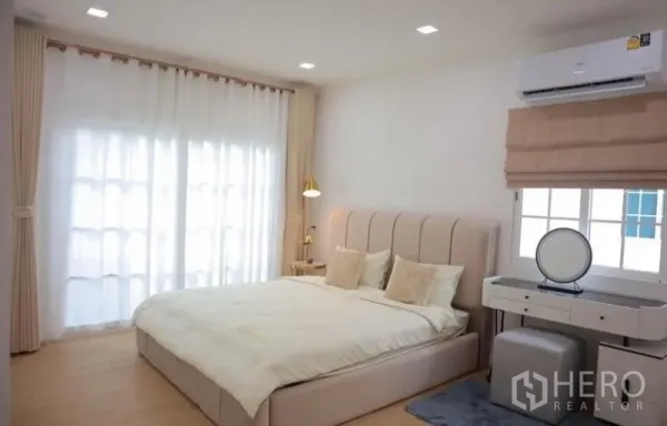 独立式住宅 出租在Bang Phli, Samut Prakan - 主卧采光充足，配大床、梳妆台和落地窗帘。