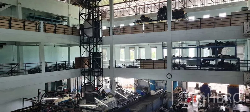 Warehouse for rent or sale in Bang Phli, Samut Prakan - High-ceiling warehouse with mezzanine storage levels and lift tower structure.