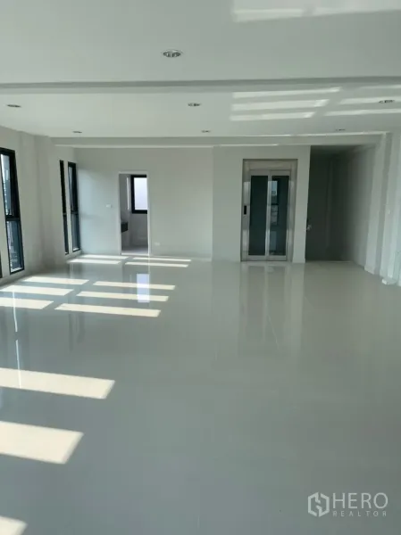 Home Office for rent in Suan Luang, Bangkok - Open-plan office floor with internal lift, recessed lighting and a doorway to the restroom.