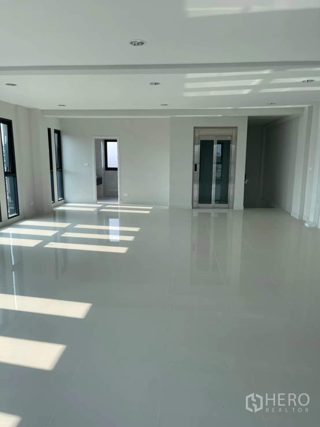 Home Office for rent in Suan Luang, Bangkok - Open-plan office floor with internal lift, recessed lighting and a doorway to the restroom.