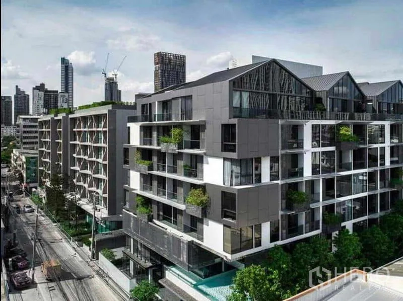 Condominium for rent in Khlong Toei, Bangkok - Modern low-rise condominium exterior with balconies and greenery in Khlong Toei.