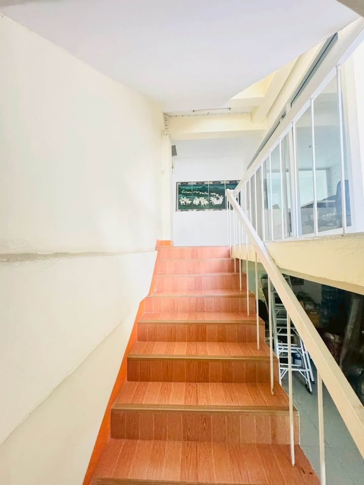 Shophouse for rent in Phra Khanong, Bangkok - Wood-look staircase with handrail connecting the shophouse floors.