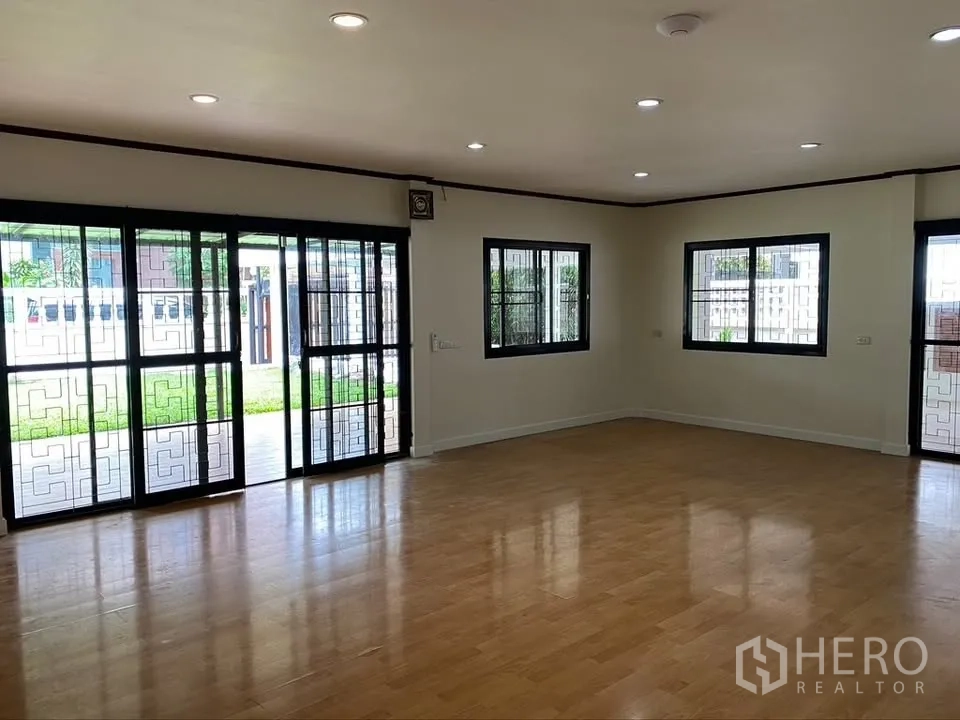 独栋房屋 for rent in Suan Luang, Bangkok - 明亮房间，木纹地板并有通往花园的推拉玻璃门。