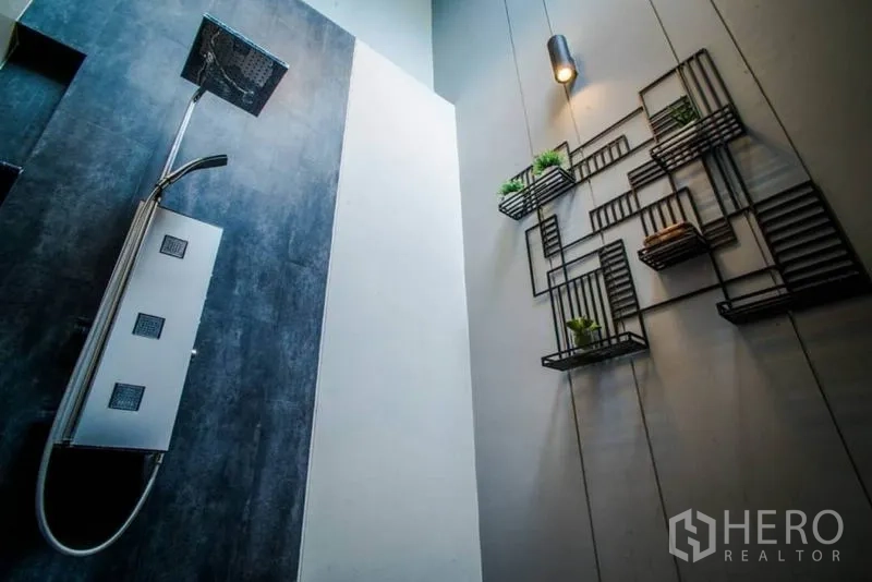 Townhouse for rent or sale in Watthana, Bangkok - Rainfall shower with dark feature wall and geometric shelving decor