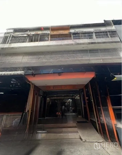 店屋 出租或出售在Watthana, Bangkok - 多层店屋的街道立面，入口内凹并带有金属栏杆阳台。