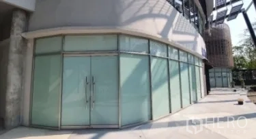 Retail Space for rent in Khlong Toei, Bangkok - Street‑level corner retail space with wraparound glass and twin entry doors.