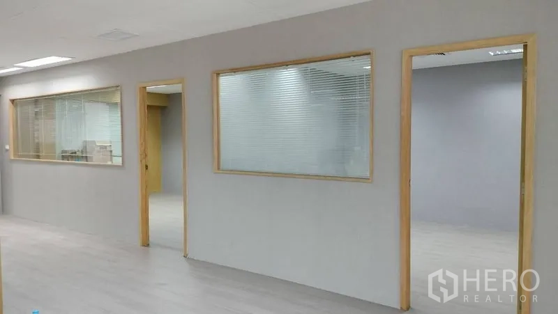 办公空间 出租或出售在Pathum Wan, Bangkok - 室内走廊，木质边框玻璃隔断通往各房间。