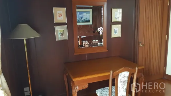 Detached House for rent in Khlong Toei, Bangkok - Cozy work desk and chair with wall mirror and framed art on dark wood paneling.