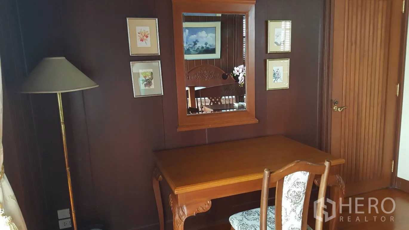 Detached House for rent in Khlong Toei, Bangkok - Cozy work desk and chair with wall mirror and framed art on dark wood paneling.