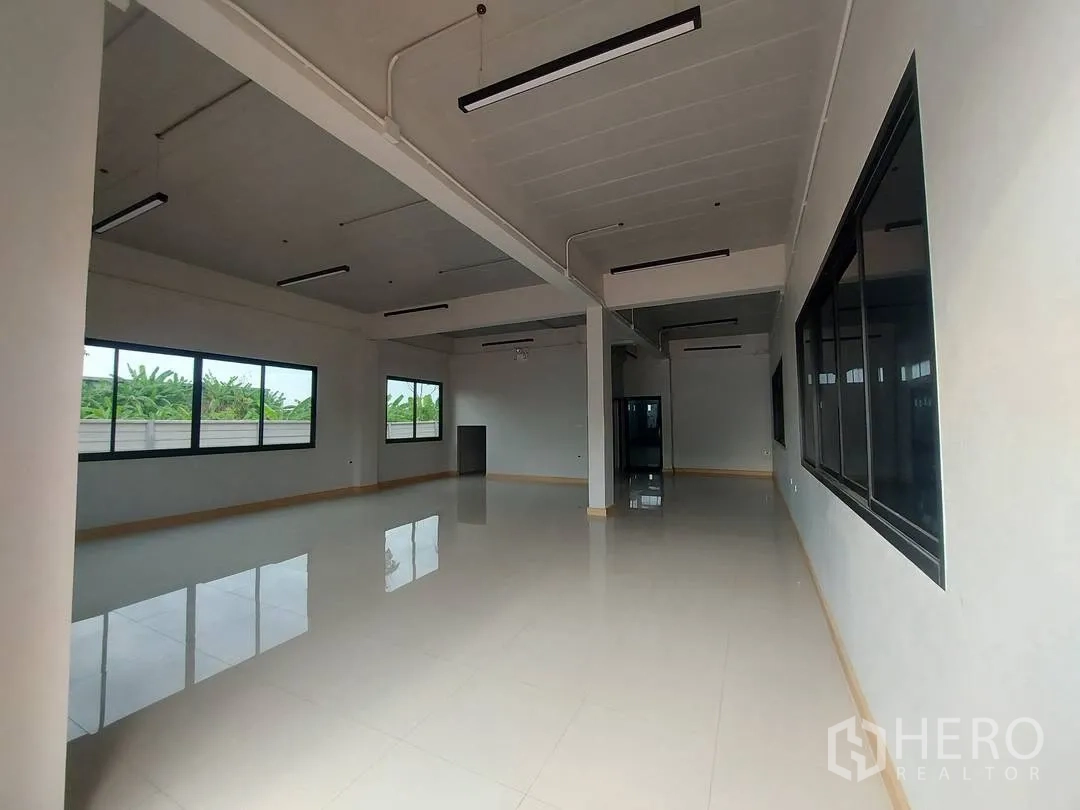 Factory for rent in Krathum Baen, Samut Sakhon - Open-plan office space with large windows to greenery and polished tile flooring.