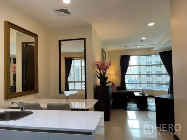 Apartment for rent in Khlong Toei, Bangkok - Open-plan kitchen, dining and lounge with large corner windows and city view.