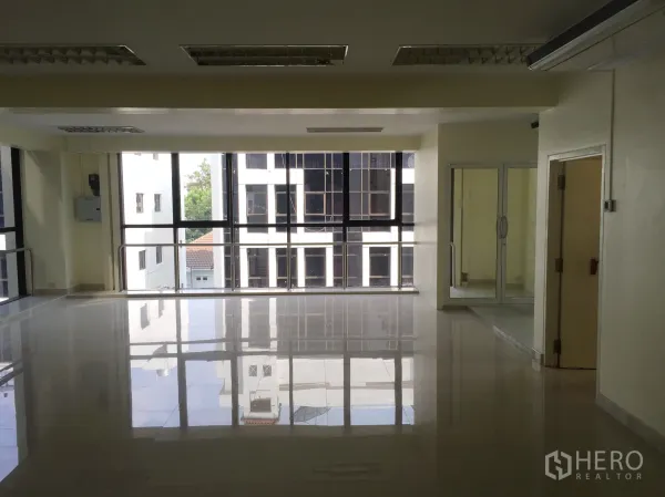 Office Space for rent in Bang Kapi, Bangkok - Open workspace with panoramic windows overlooking nearby buildings and polished tiles.