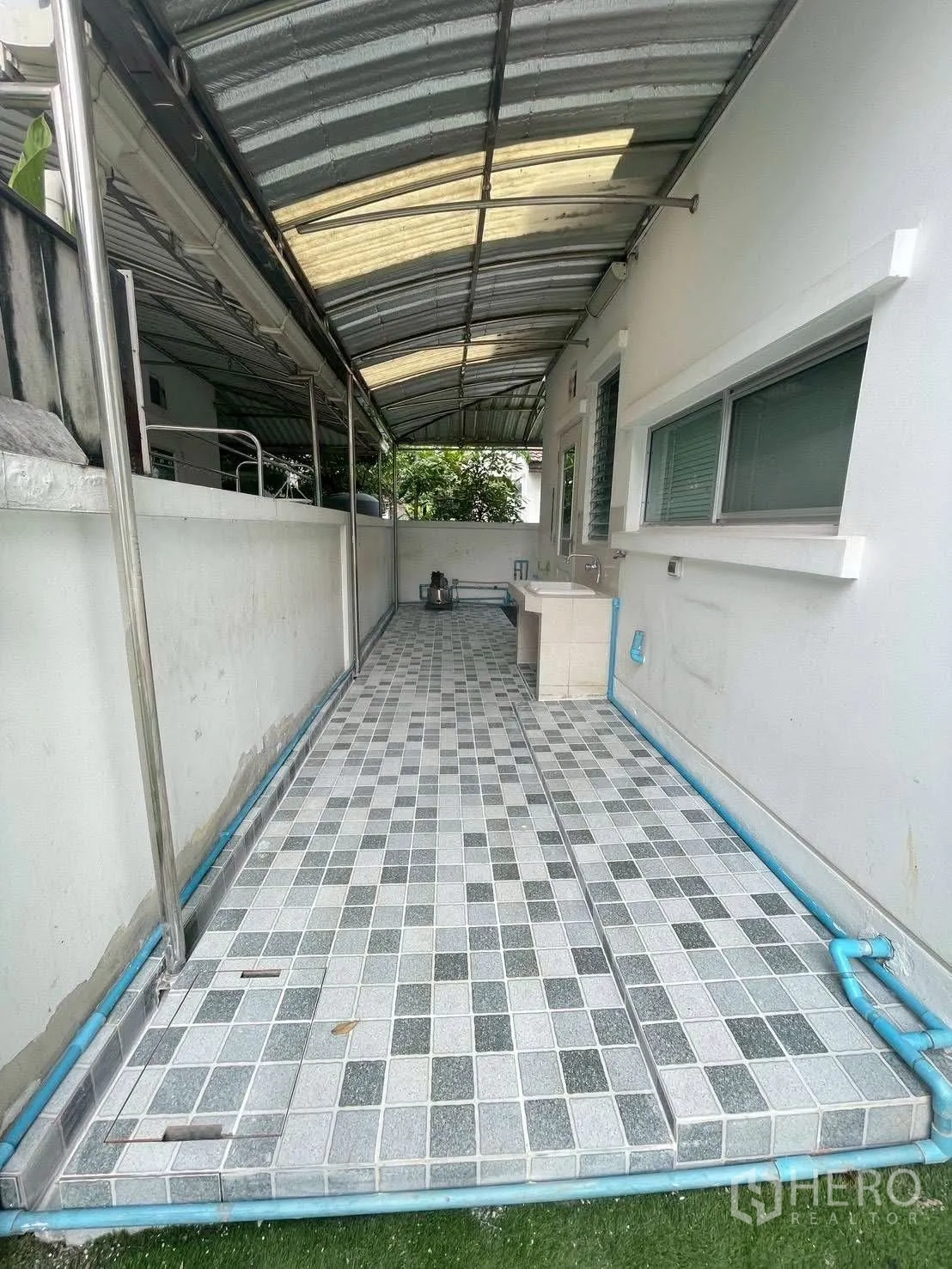 Detached House for rent or sale in Mueang Samut Prakan, Samut Prakan - Covered service area with tiled floor, metal roof, utility sink and exposed piping along the wall.