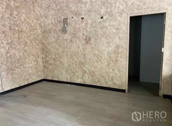 Retail Space for rent in Bang Rak, Bangkok - Unfurnished retail corner with textured walls and access to a back room.