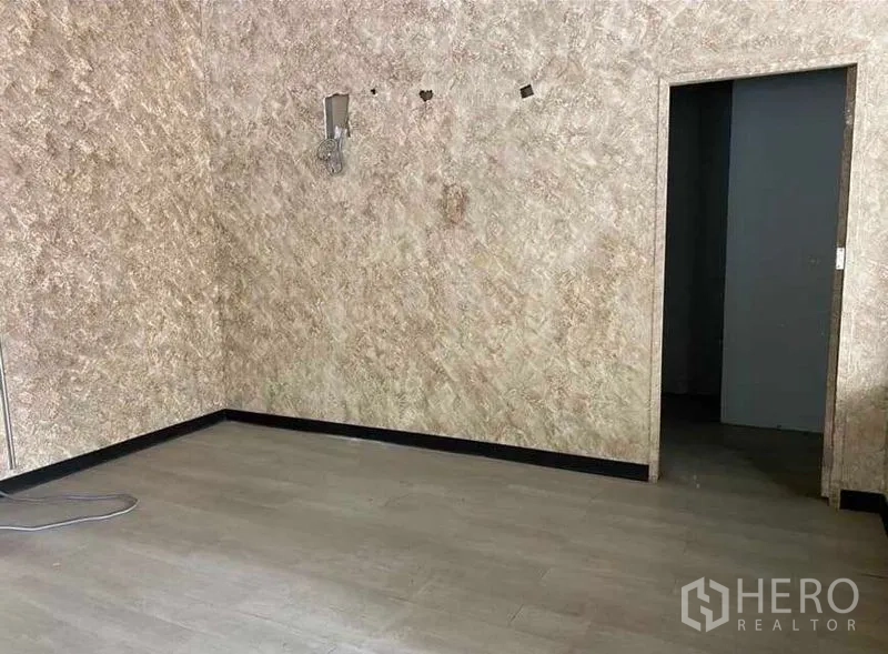 Retail Space for rent in Bang Rak, Bangkok - Unfurnished retail corner with textured walls and access to a back room.