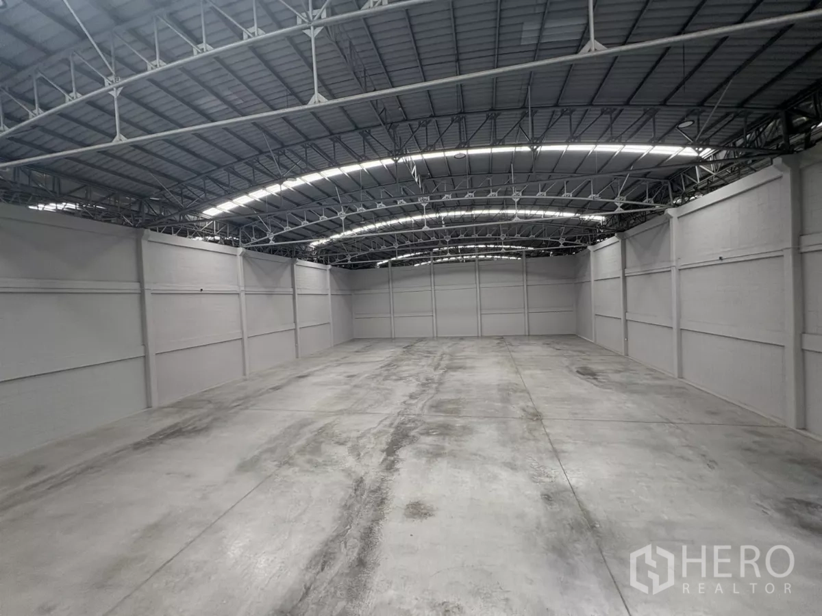 Factory for rent in Bang Phli, Samut Prakan - Large clear-span warehouse with high arched steel roof and concrete floor.