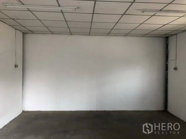 Warehouse for rent in Khlong Luang, Pathum Thani - Small office room inside the warehouse with drop ceiling and fluorescent lighting.