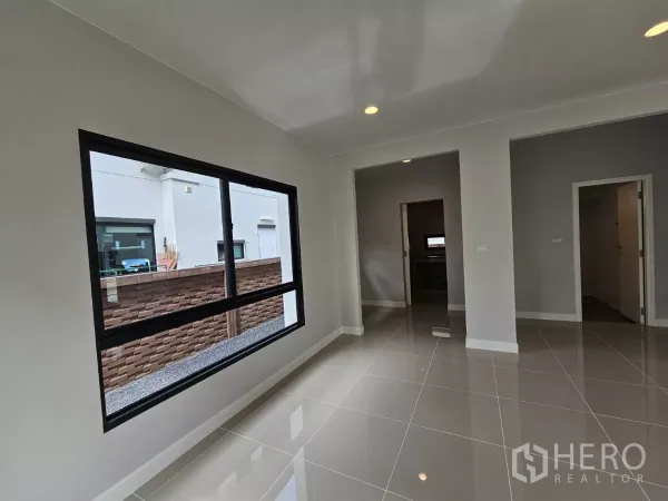 Detached House for sale in Lam Luk Ka, Pathum Thani - Ground-floor multipurpose room with a wide window and neutral walls.