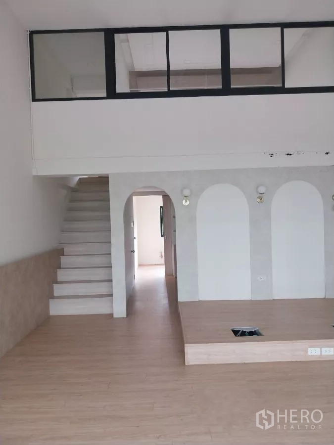Retail Space for rent - Retail floor showing a stage platform, arches and stairs leading to the upper mezzanine.