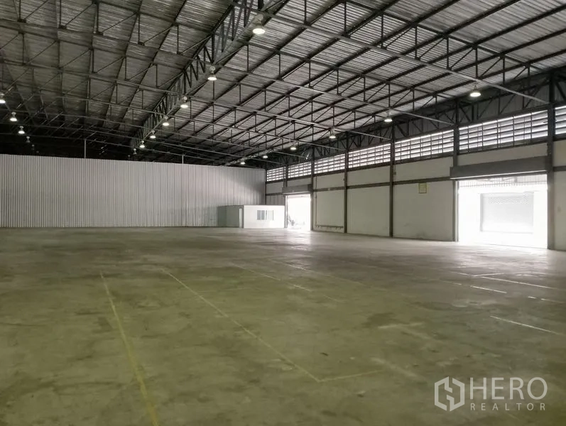 Warehouse for rent in Bang Phli, Samut Prakan - Wide warehouse floor with multiple loading doors and ventilated side windows.