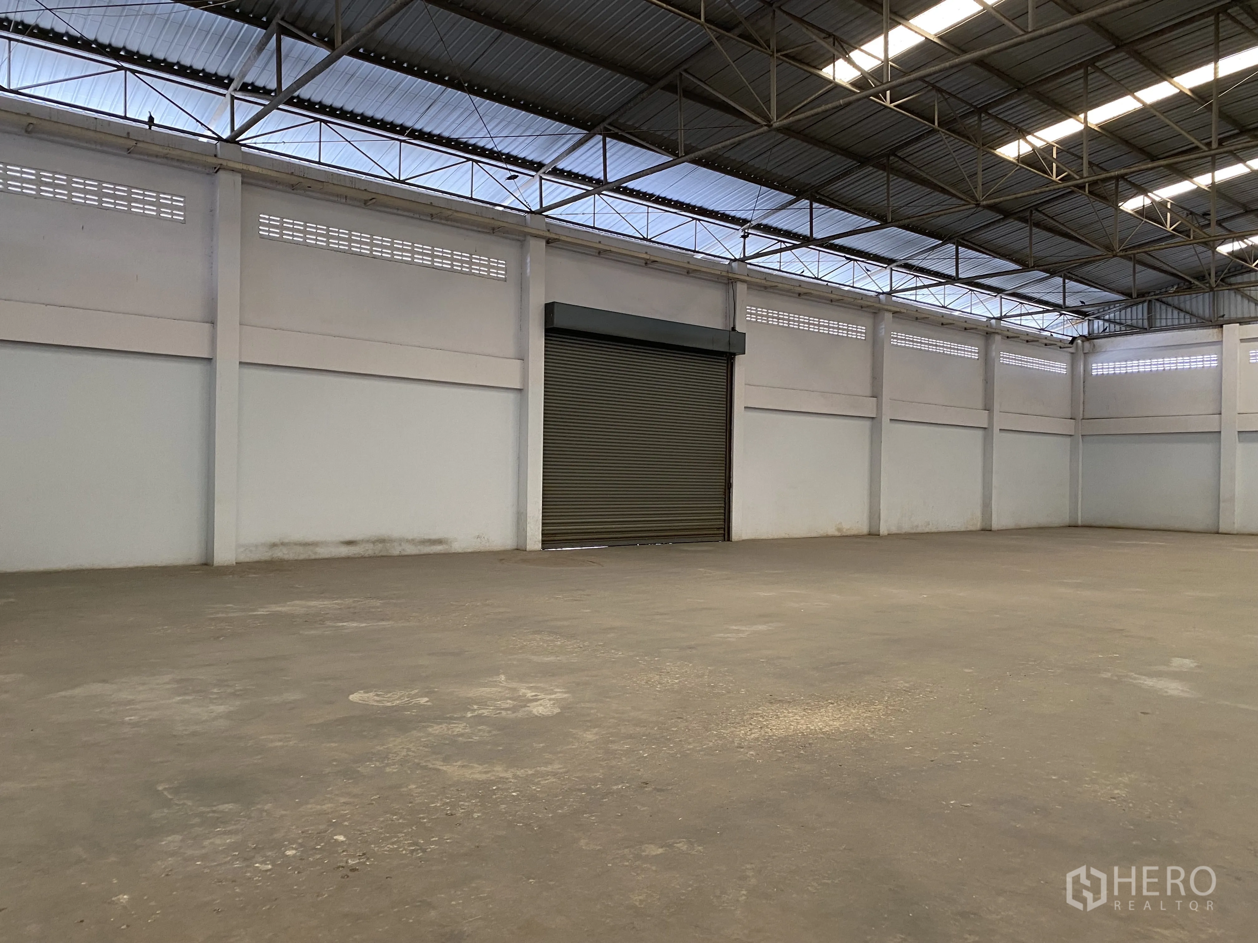 工厂 for sale in Khlong Luang, Pathum Thani - 仓库角落的宽幅卷闸门。