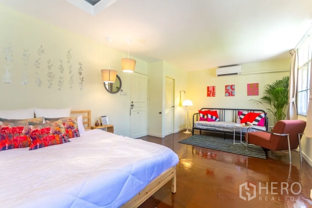 Home Office for rent in Suan Luang, Bangkok - Large bedroom with bed, sofa seating area and colorful cushions.