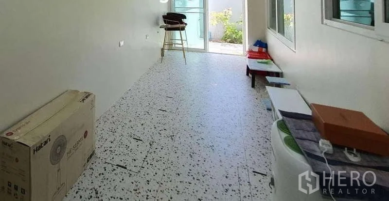 Detached House for rent in Prawet, Bangkok - Enclosed side corridor with terrazzo floor leading to a sliding glass door.