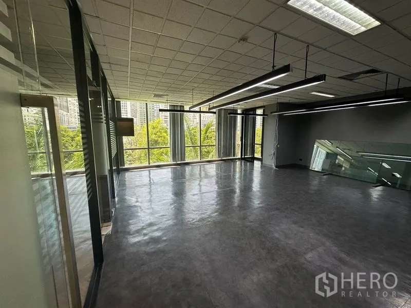Office Space for rent - Bright workspace with large windows, suspended LED strips and leafy city views.