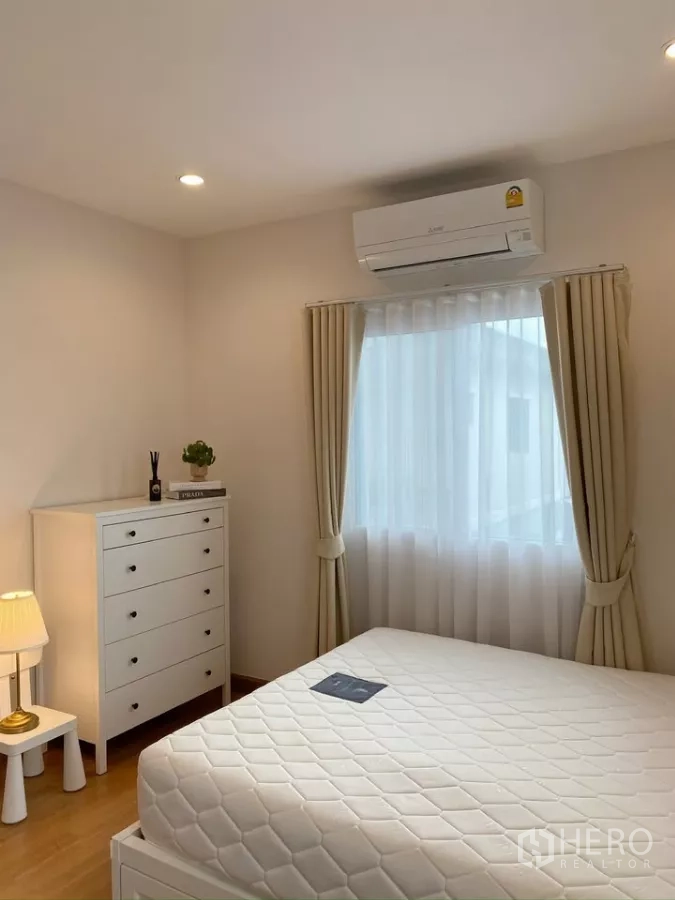 Detached House for sale in Sai Mai, Bangkok - Bright secondary bedroom with dresser, air conditioner and soft curtains.
