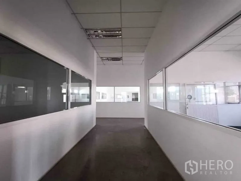 Warehouse for rent or sale in Pathum Thani - Internal corridor with large viewing windows into the production or storage area.