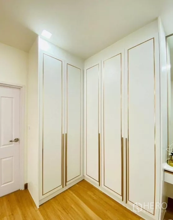 Detached House for rent in Prawet, Bangkok - Corner walk-in wardrobe with tall white cabinets and gold trim detailing.