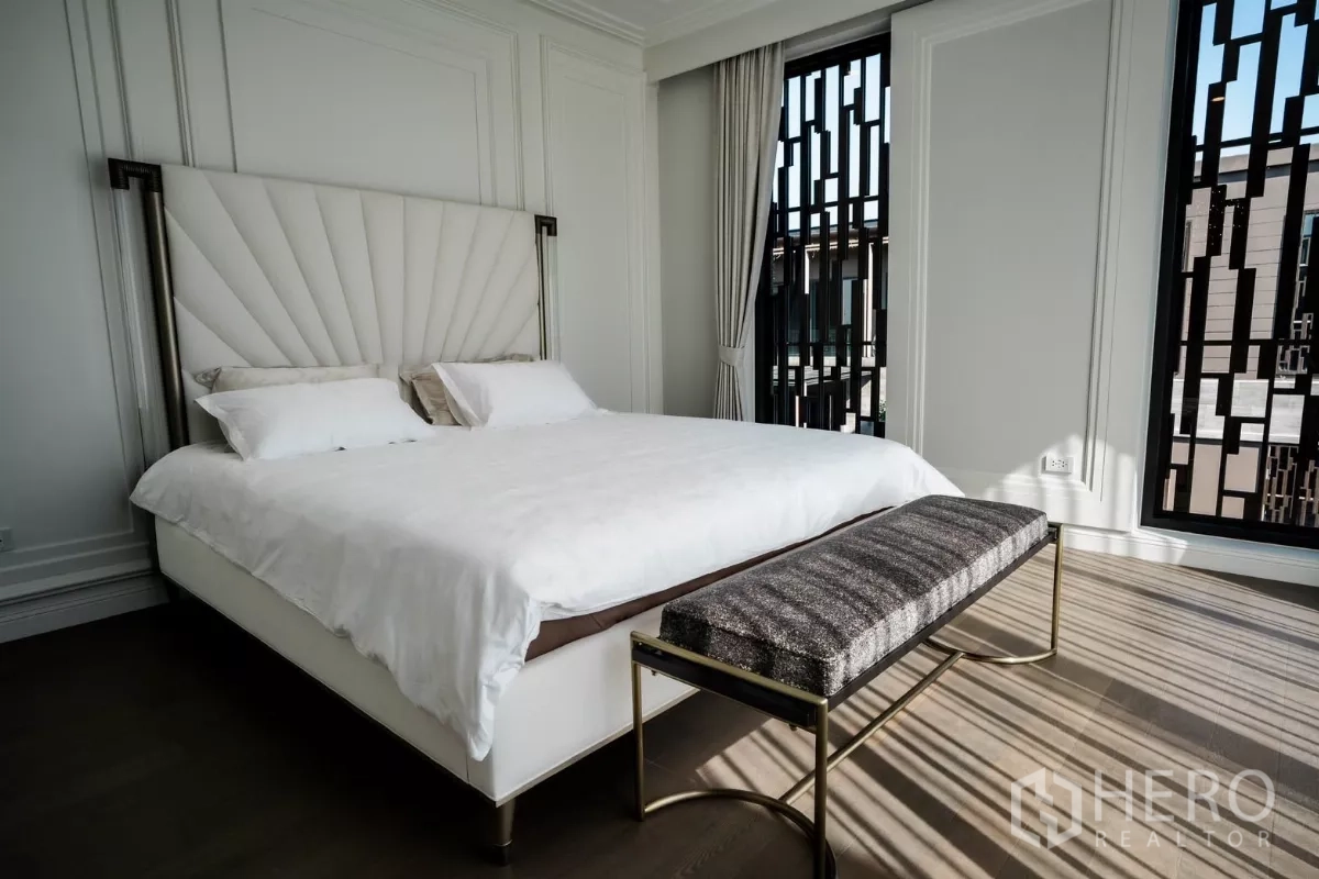 Detached House for rent or sale in Bang Kapi, Bangkok - Master bedroom angle showing patterned window screens and elegant white walls.