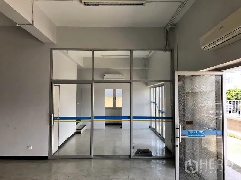 Factory for rent in Pathum Thani - Ground-floor office lobby with glass partition walls and A/C units.