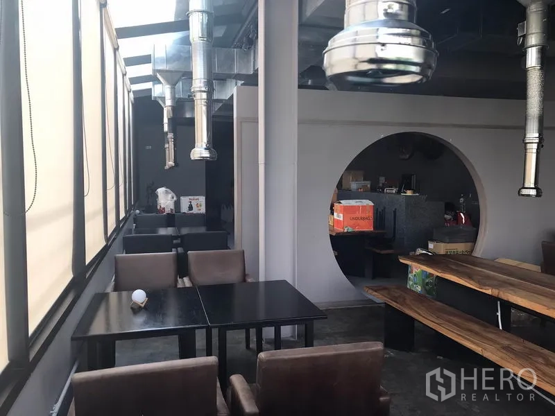 Retail Space for rent in Watthana, Bangkok - Window-side seating with square tables, a circular feature doorway and overhead vents.